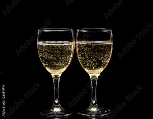 Two crystal wine glasses with a drink, falling ice and splashes