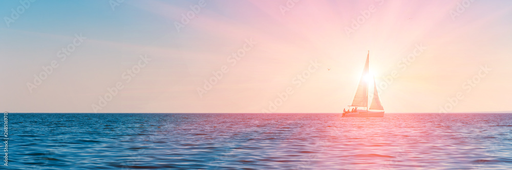 Fototapeta Banner 3:1. Sailboat in the sea in the evening sunlight over sky background. Luxury summer adventure or active vacation concept. Copy space.