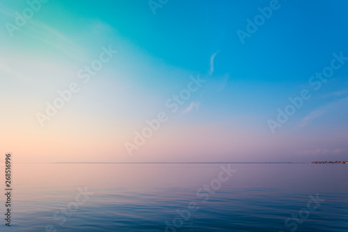 Horizontal sea line in the evening sunlight over sky background. Blue hour sunset. Summer adventure or vacation concept. Copy space.