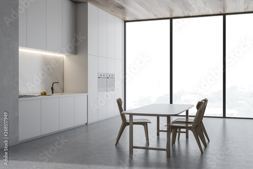 Loft concrete kitchen corner with wooden table