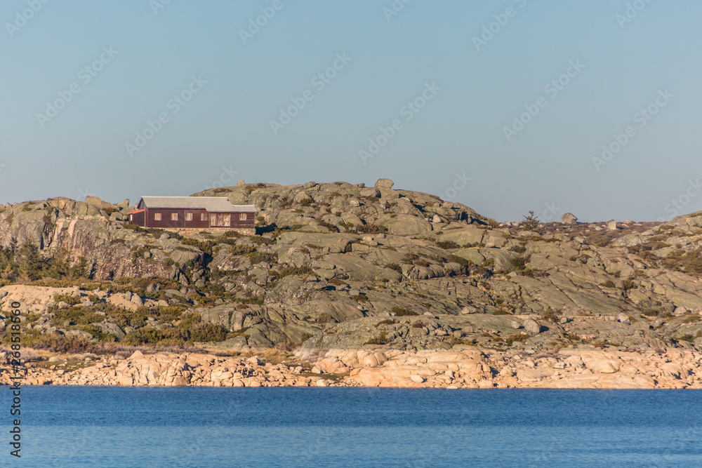 View of dam Marques da Silva and long lagoon , lagoa comprida, granitic rock geology on banks with a building