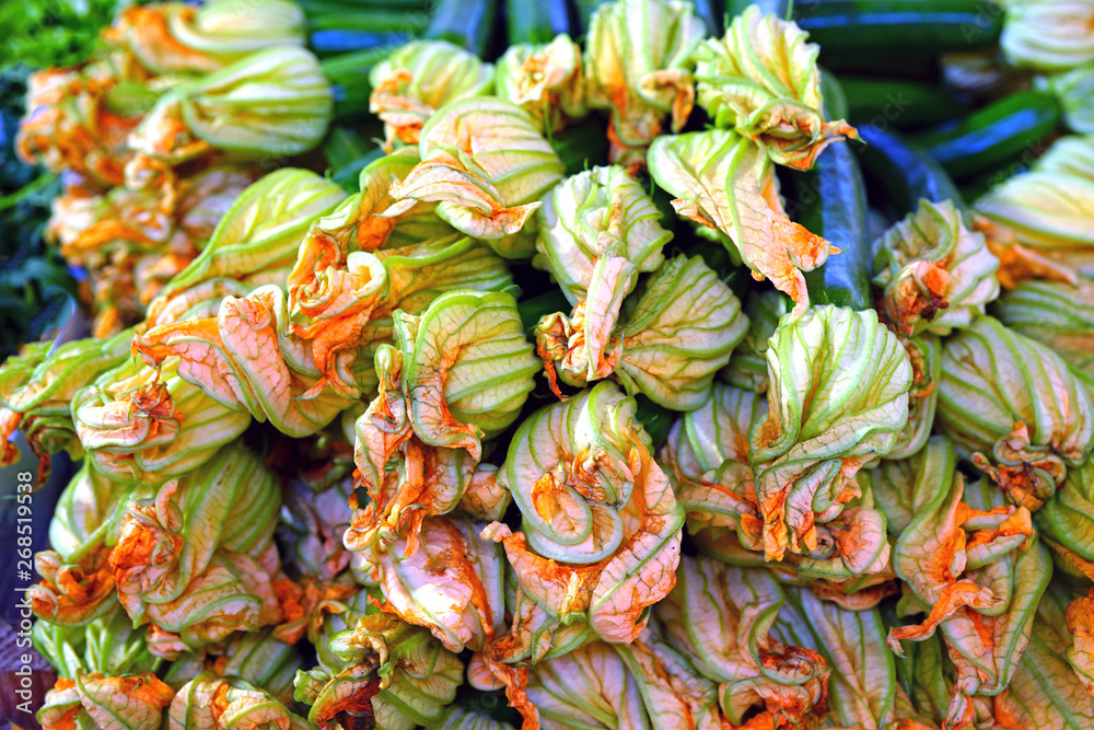 Zucchini flower blossoms in a crate at an Italian farmers market