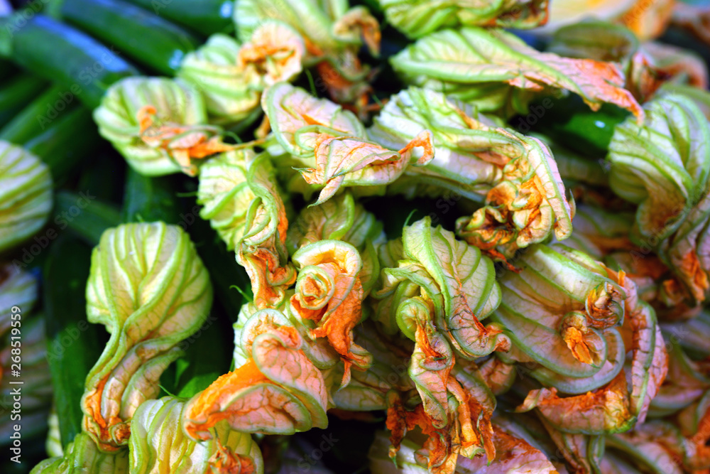 Zucchini flower blossoms in a crate at an Italian farmers market
