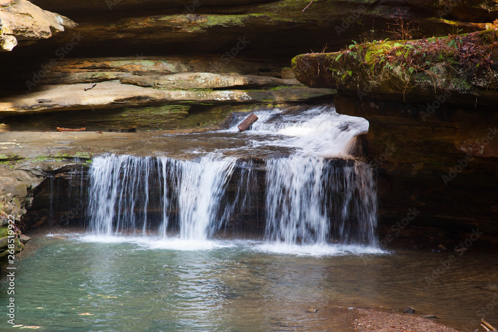 Obraz premium Waterfall outdoors with a stream and rocks