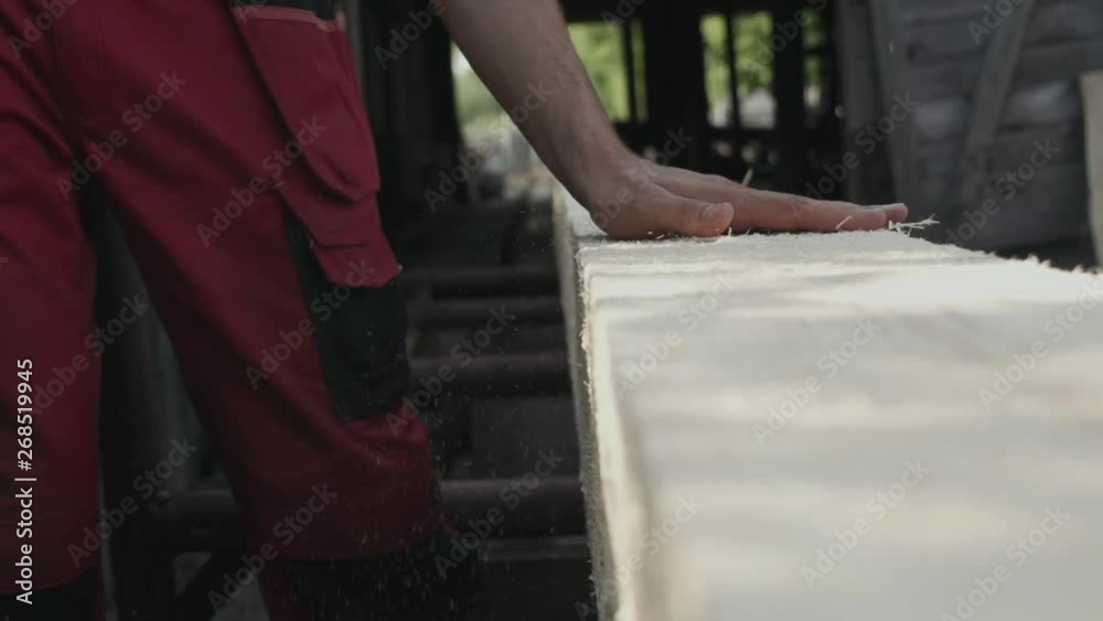 man's hand sweeps sawdust from a wooden beam in production slow motion man's hand sweeps sawdust from a wooden beam in production slow motion