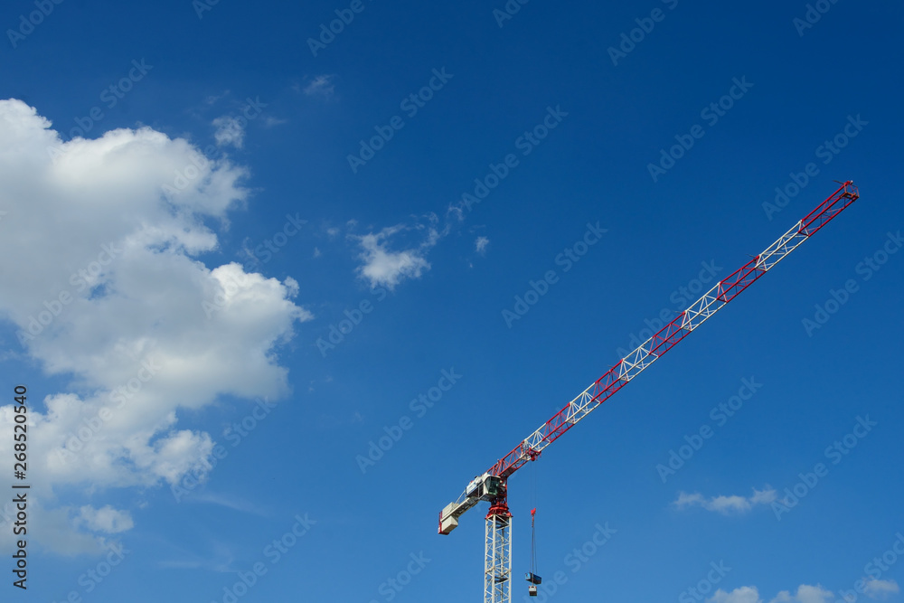 tower cranes against blue sky with white clouds tower cranes against blue sky with white clouds