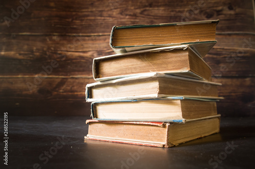 A Stack of old books. Wooden background. Selective focus.