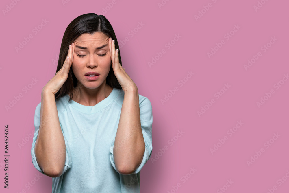 Woman overwhelmed with stress and concern, confusion and doubt, hands to head, on pink background copy space - obrazy, fototapety, plakaty 