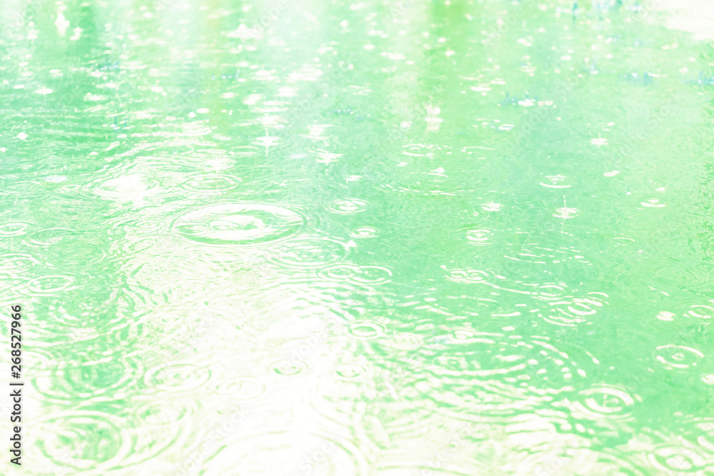 Raindrops on a puddle on a rainy day. Soft blue tone. Beautiful background. Raindrops on a puddle on a rainy day. Soft blue tone. Beautiful background.