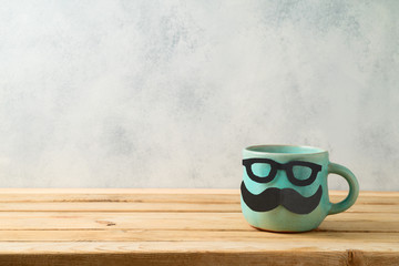 Happy Father's day concept with cute funny coffee mug over wooden background