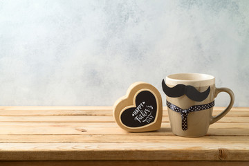 Happy Father's day concept with coffee mug and gift box over wooden background