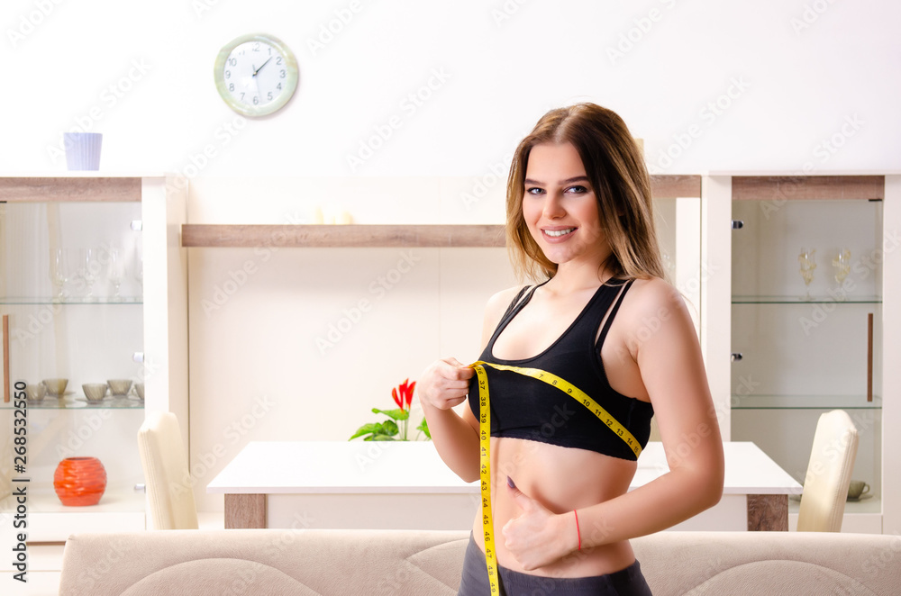 Obraz premium Young beautiful girl with tape meter in dieting concept 