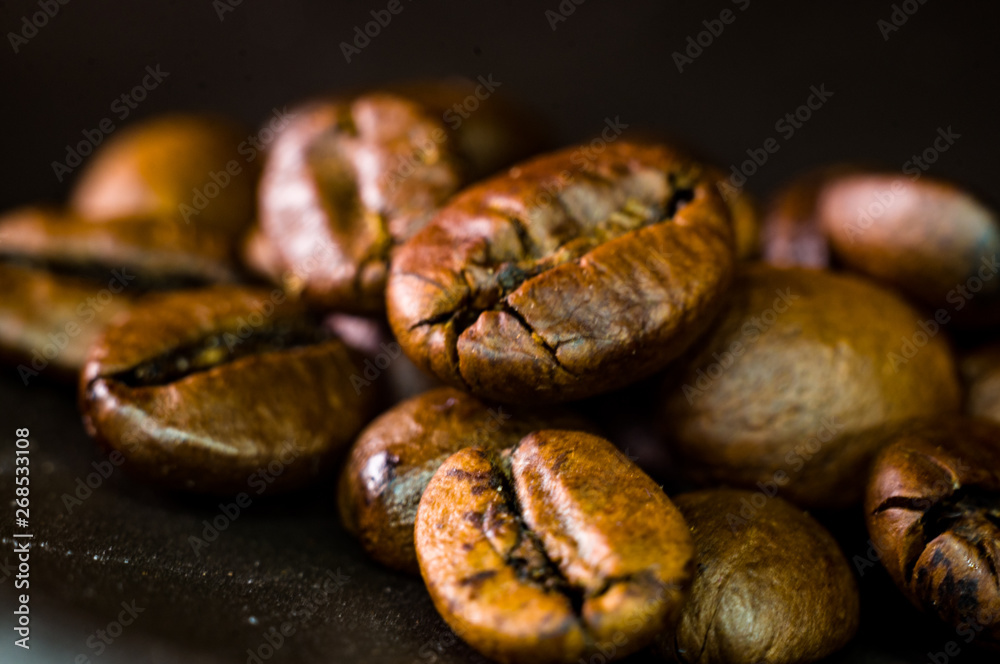 Brown roasted coffee beans on black background, close up, macro Brown roasted coffee beans on black background, close up, macro