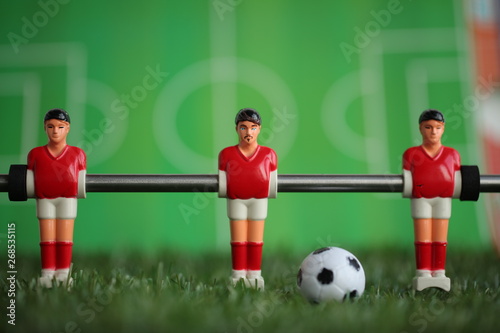 Red foosball plastic players. Soccer ball