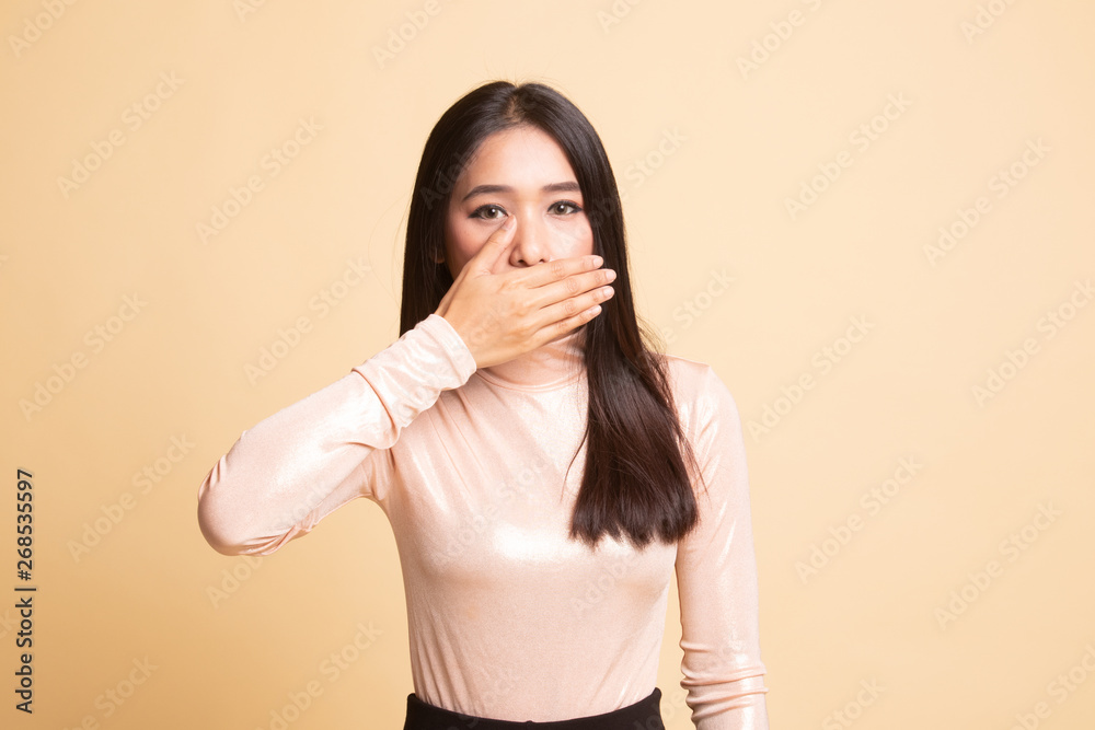 Young Asian woman close her mouth with hand.