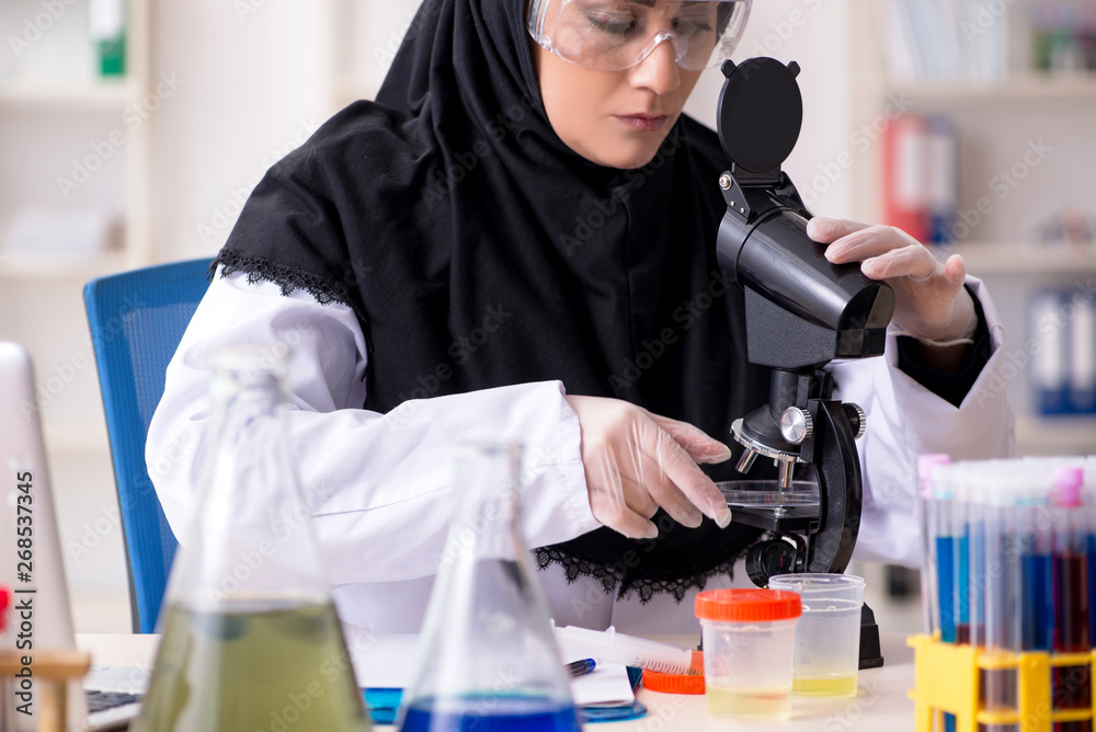 Female chemist in hijab working in the lab Female chemist in hijab working in the lab