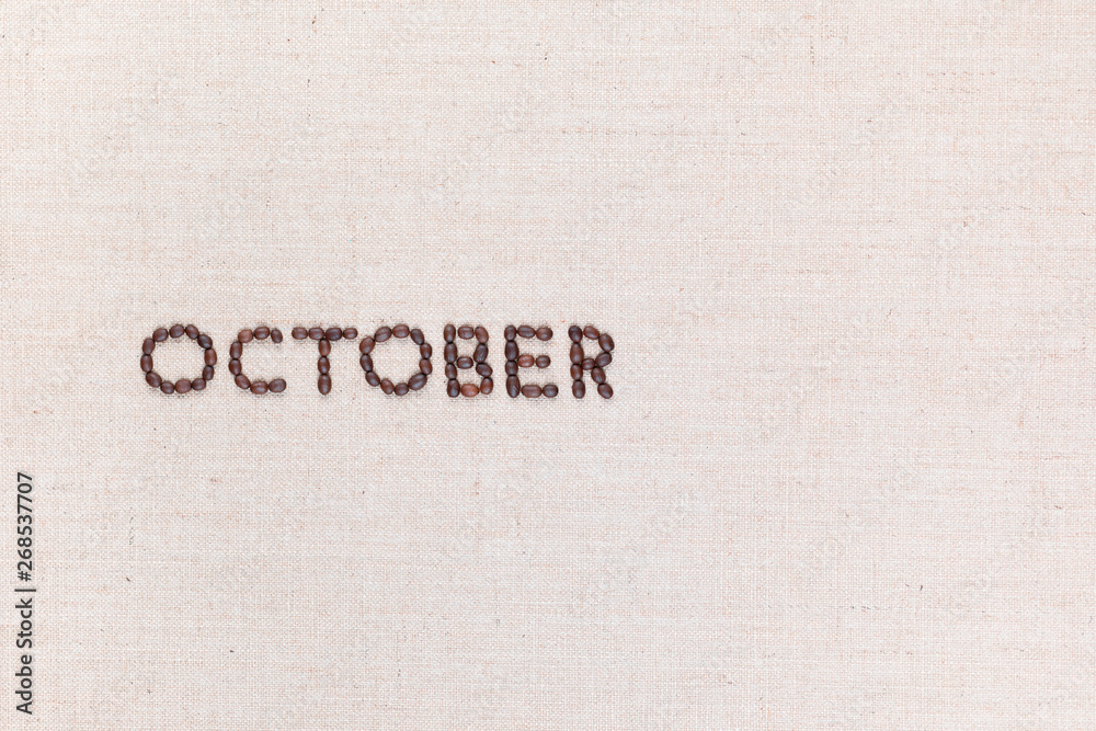 The word October written with coffee beans shot from above, aligned to the left. The word October written with coffee beans shot from above, aligned to the left.