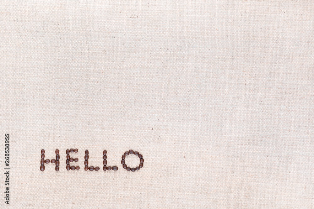 The word Hello written with coffee beans shot from above, aligned at the bottom left.