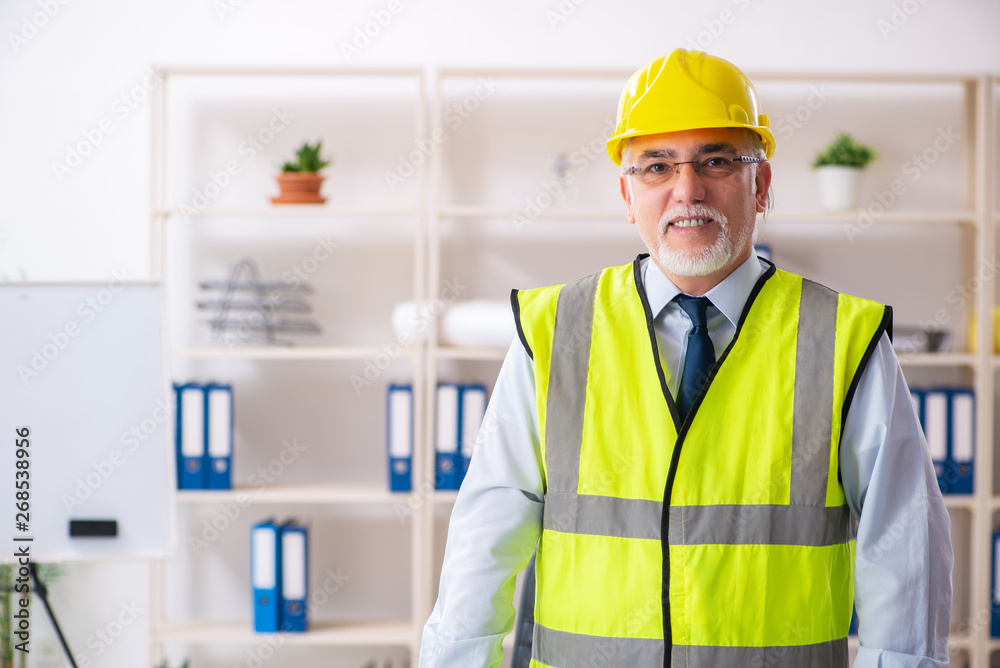 Aged construction engineer working in the office Aged construction engineer working in the office