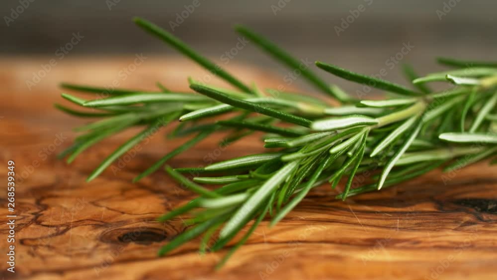 Super slow motion of falling rosemary on cutting board Super slow motion of falling rosemary on cutting board