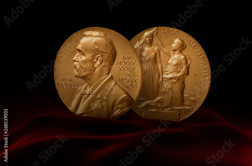 Alfred Nobel Prize. Two medals standing on red fabric. photo