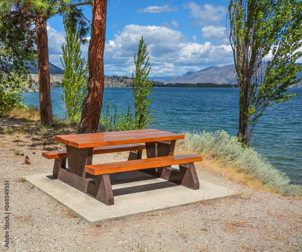 Obraz premium Picnic area with table and benches on a shore of Okanagan lake