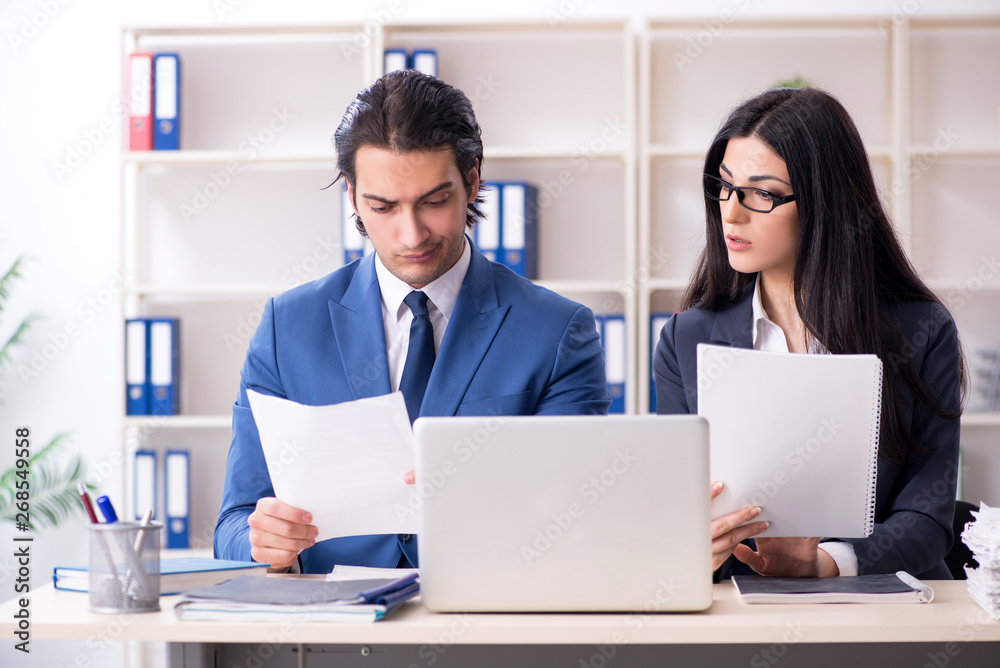 Two employees working in the office Two employees working in the office