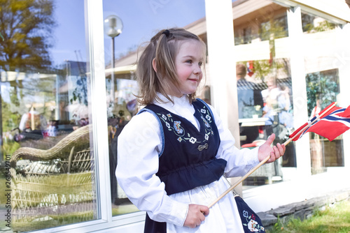 Girl 4-5 years old in norwegian national dress holding a Norwegian flag. photo