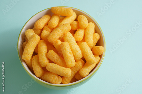 Cheese flavored puffed corn snacks