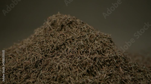 Black Tea shot in slow motion with tea leaves falling. Good background