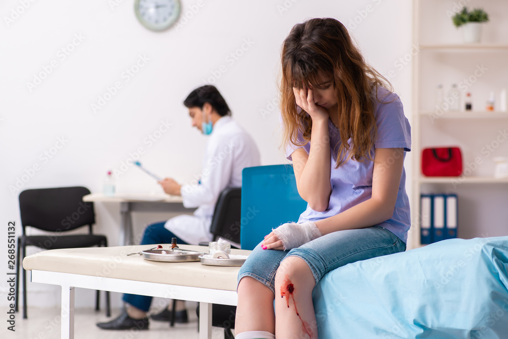 Leg injured young woman visiting male doctor Leg injured young woman visiting male doctor