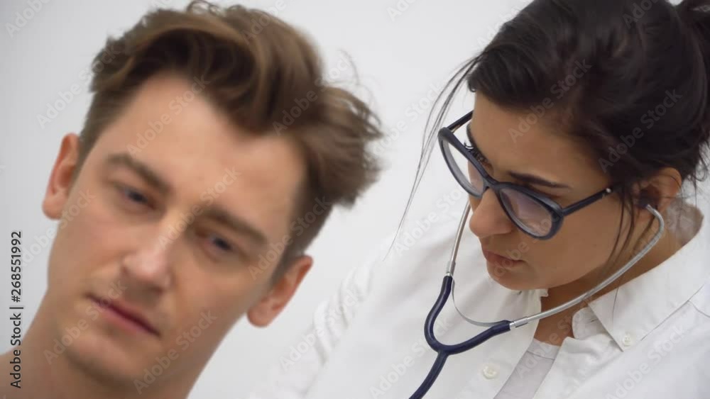 Professional lady doctor examining a young patient with focus, close up shot Professional lady doctor examining a young patient with focus, close up shot