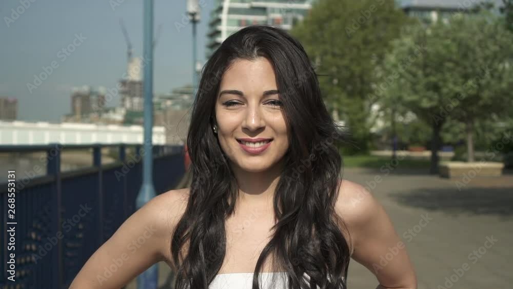 Slow Motion Portrait of a beautiful hispanic latina young woman looking at the camera and show emotions from serious to smiling and laughing Slow Motion Portrait of a beautiful hispanic latina young woman looking at the camera and show emotions from serious to smiling and laughing