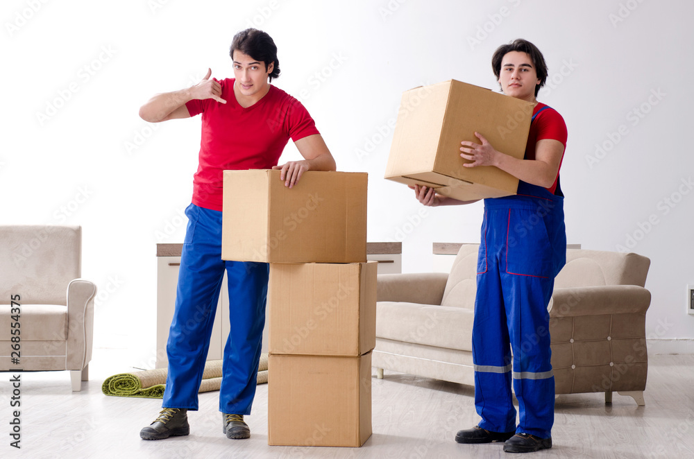 Two young contractor employees moving personal belongings