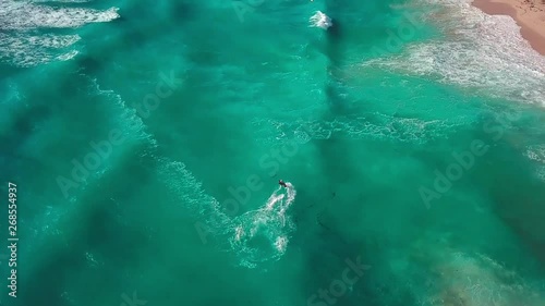 Top down aerial view, Kitesurfer jumping and falling into the water.