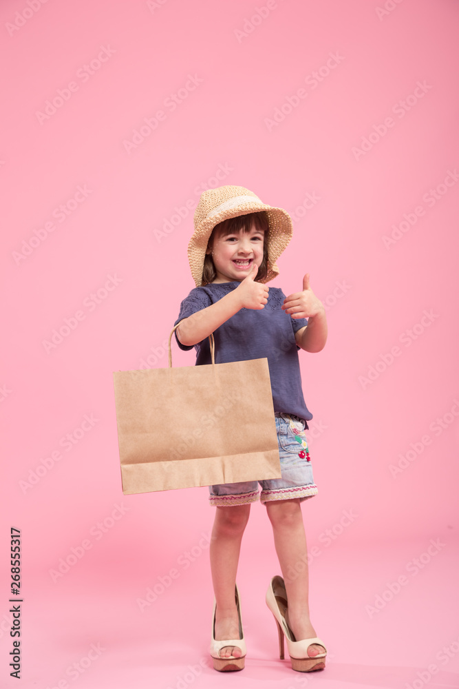 Funny little girl is a fashionista in the shoes of the mother Funny little girl is a fashionista in the shoes of the mother