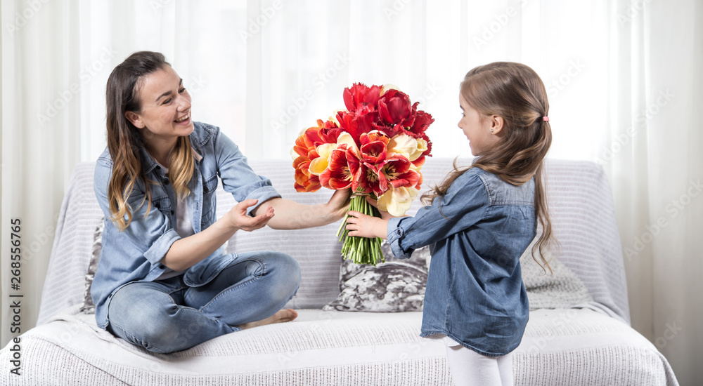Mother's day. Little daughter with flowers congratulates her mother Mother's day. Little daughter with flowers congratulates her mother