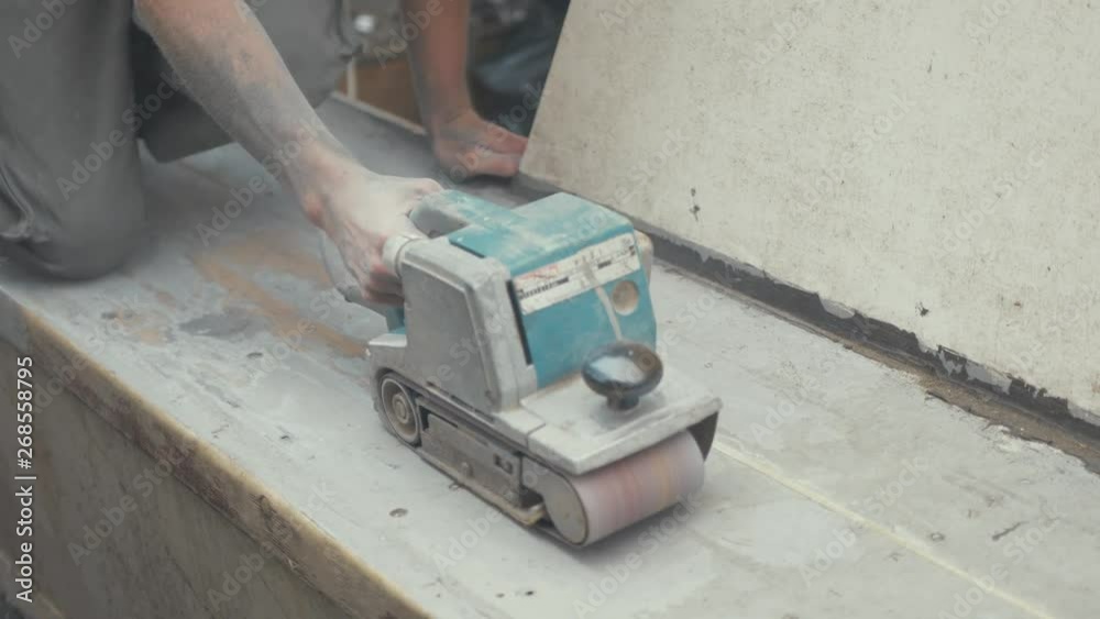 Young working topless in Summer sealing wooden boat cabin roof to