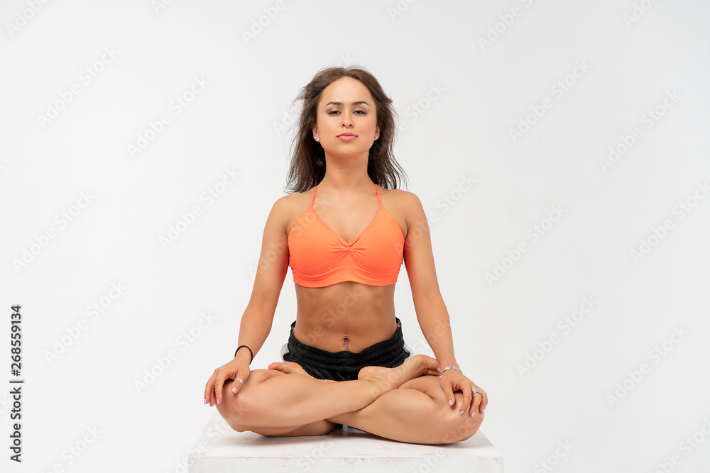 young woman doing yoga in Lotus position on white background