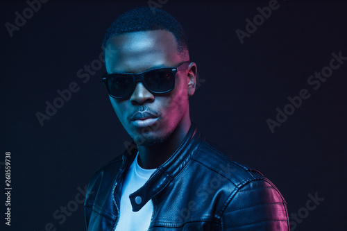 Bilde på lerret African American man looking through black eyewear in nightclub with neon rays o