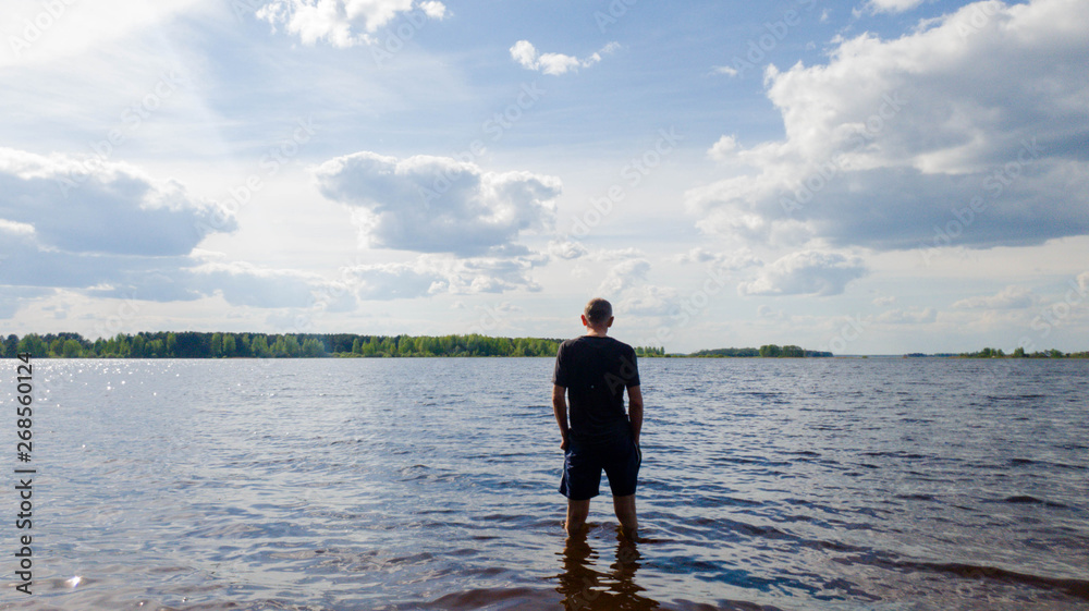 A man walks into the river. A man by the river in the summer. A man walks into the river. A man by the river in the summer.