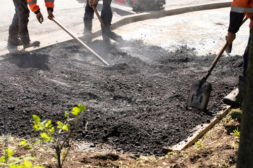 Road Builders laid Asphalt-Teamwork. Asfaltobetonnye work on. d. Hot asphalt gravel, level workers.