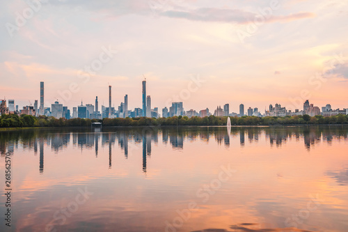 Sunset View of Manhattan skyline from Jacqueline Kennedy Onassis Reservoir in Central Park, reflection in water © valeragf