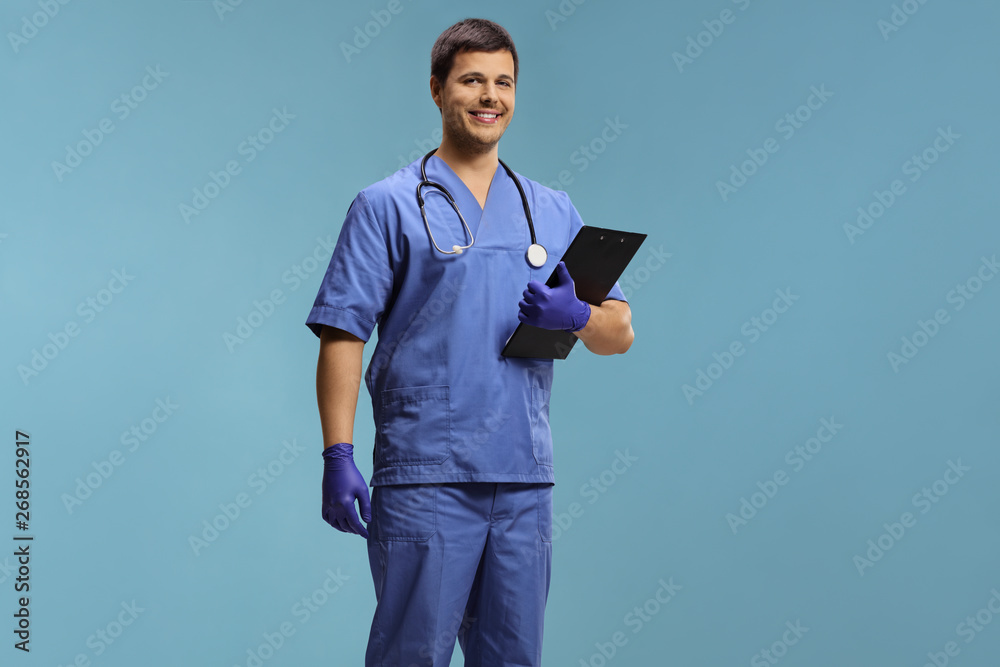 Young male doctor in a uniform wearing gloves and holding a clipboard Young male doctor in a uniform wearing gloves and holding a clipboard