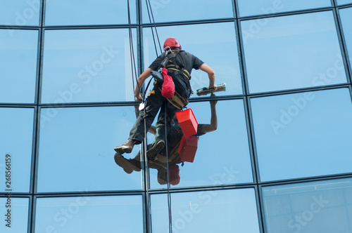 portrait of worker washing windows of the modern building.