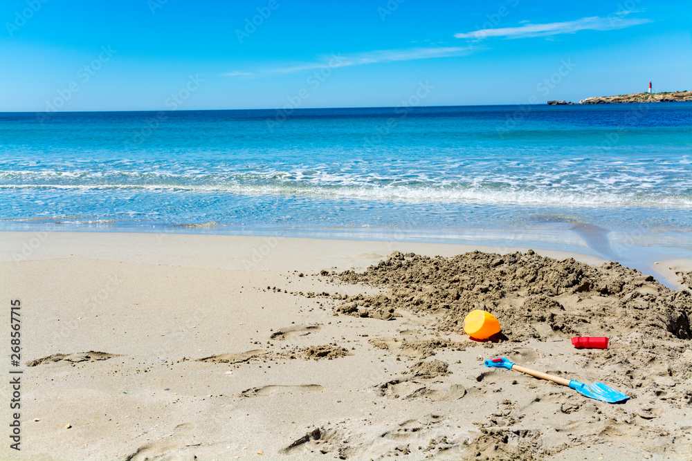 Crystal clear blue Mediterranean sea water on St.Croix Martigues beach and kids beach toys, Provence, France Crystal clear blue Mediterranean sea water on St.Croix Martigues beach and kids beach toys, Provence, France