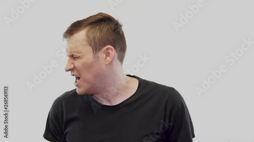 Crop person slapping scared man in face Emotional male getting slapped in face while shouting with closed eyes in fear on white background