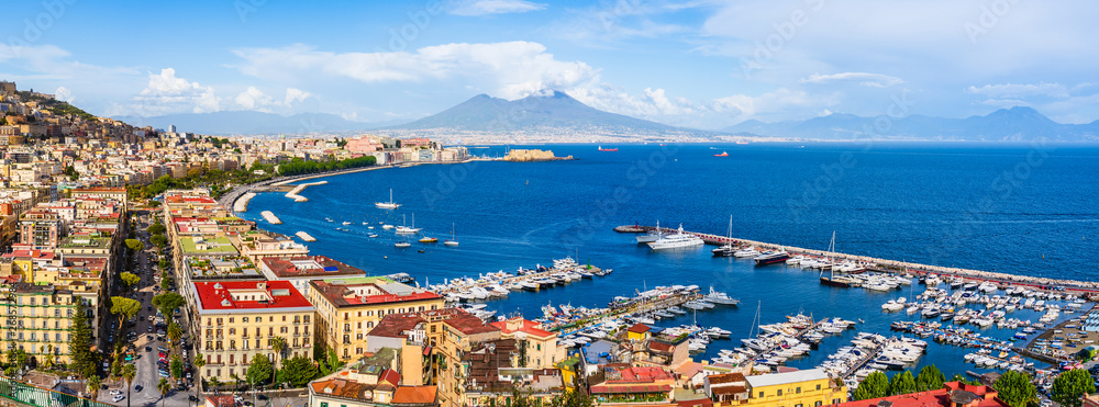 Fototapeta premium Naples city and port with Mount Vesuvius on the horizon seen from the hills of Posilipo. Seaside landscape of the city harbor and golf on the Tyrrhenian Sea