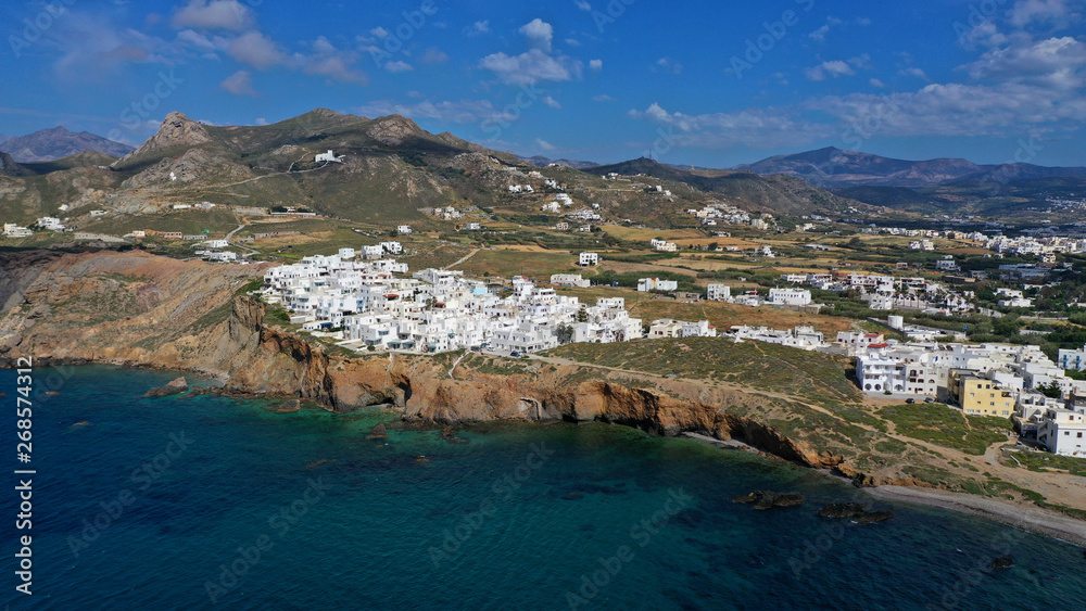 Aerial drone photo of iconic new settlement of Grotta perched on the hill and emerald clear rocky sea below, Naxos island, Cyclades, Greece