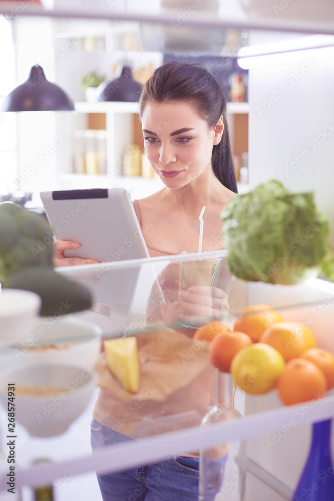 Young woman with glass of tasty healthy smoothie at table in kitchen Young woman with glass of tasty healthy smoothie at table in kitchen